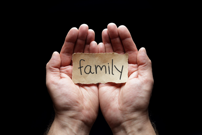 Family with the protection of cupped hands, concept for love, health, security and care